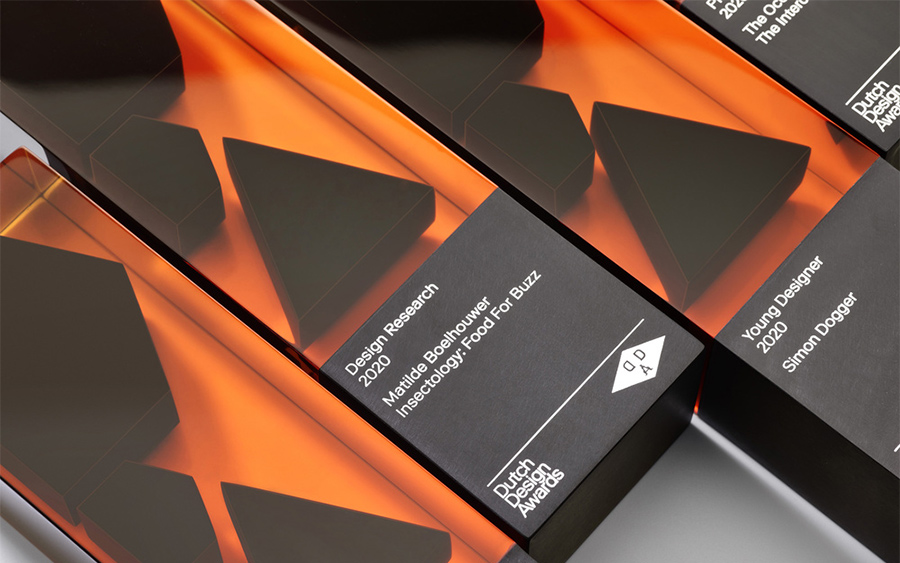 Détail de plusieurs trophées Dutch Design Awards avec la catégorie et le lauréat gravés sur le socle noir